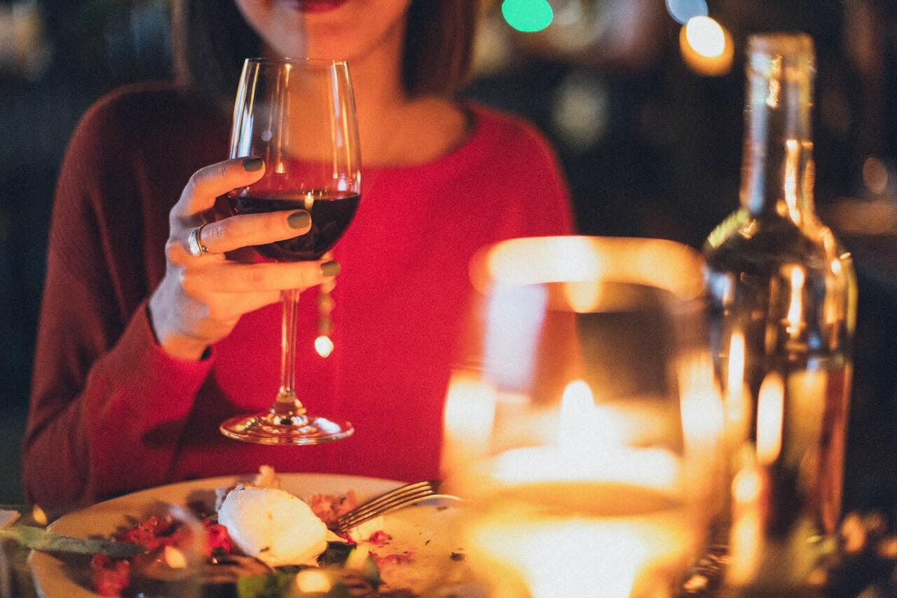 Imagen de una mujer con un vaso de vino en un restaurante